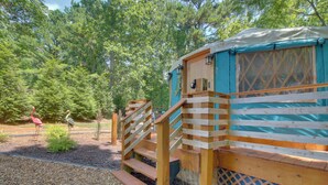 A wooden cabin with a staircase leading to a lofted sleeping area, surrounded by a forest. - Unplugged Retreat! Unique Yurt w/ Deck in Smokies (Sparta)