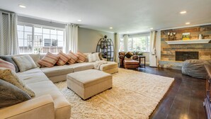 A spacious living room with a large sectional sofa, a fireplace, and a stone accent wall.