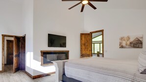 Une chambre à coucher avec un lit, une télévision, une porte en bois et une fenêtre.