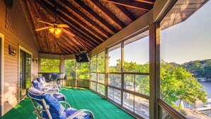 A covered outdoor area with a green floor, metal chairs, and a ceiling fan. - Dock & Prime Location: Lakefront Osage Beach Home (Osage Beach)