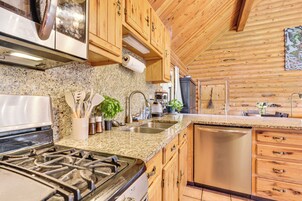 A kitchen with granite countertops, wooden cabinets, stainless steel appliances, and a dishwasher.