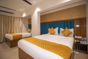 A hotel room with two beds, each with a yellow quilted bedspread and matching pillows. - Hotel Crystal Palace (Mumbai)