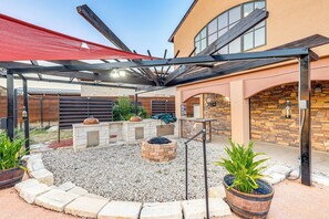A covered outdoor patio with a fire pit, seating area, and potted plants. - Italian-styled Home w/ Lake Views & Private Pool (Belton)