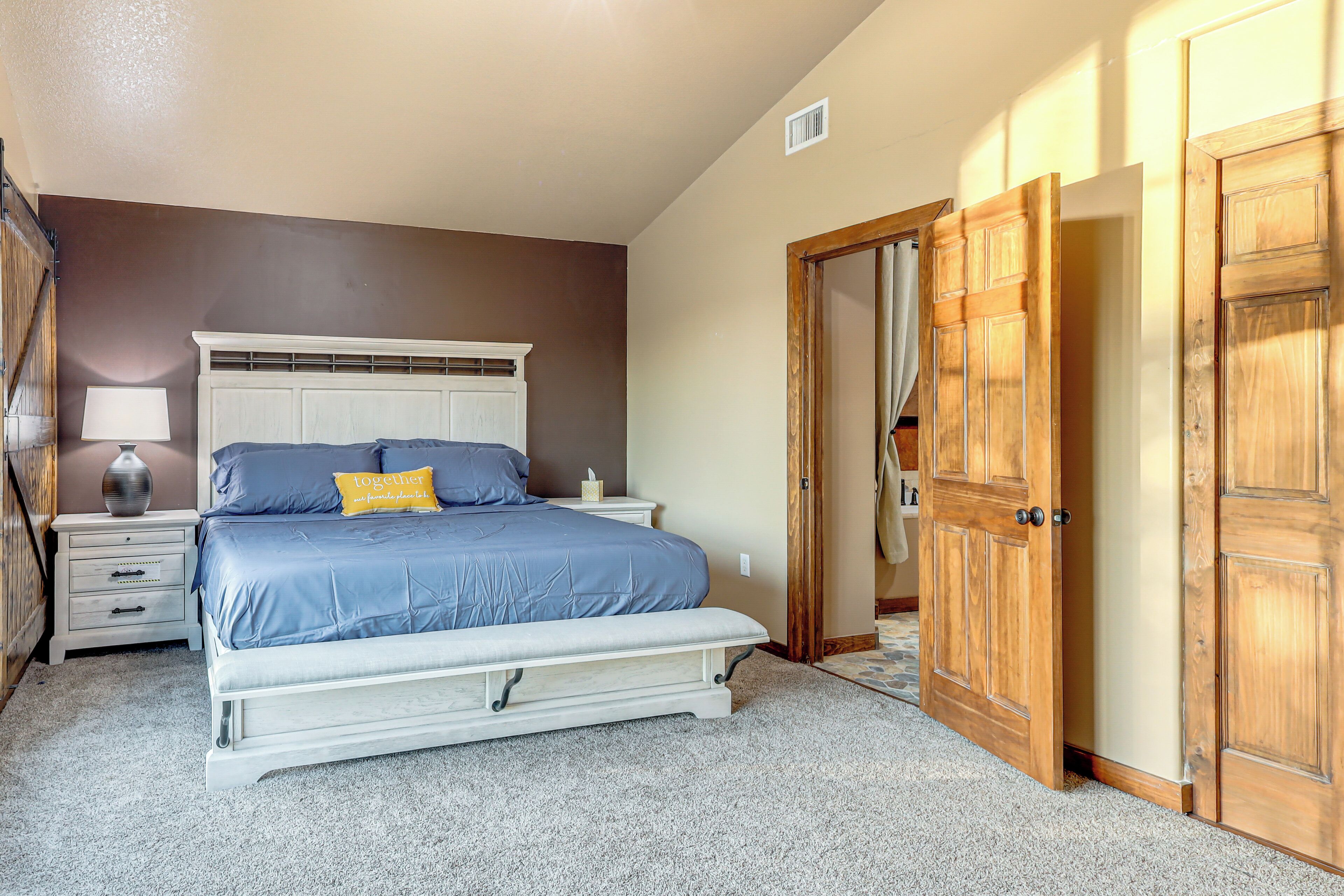 Une chambre à coucher avec un lit, des tables de chevet, une lampe et une armoire.