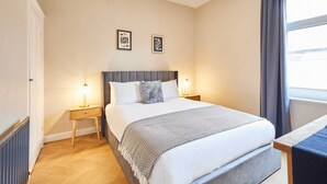 A neatly arranged bedroom with a bed, bedside tables, and a window with curtains. - Host Stay Horner Street (York)