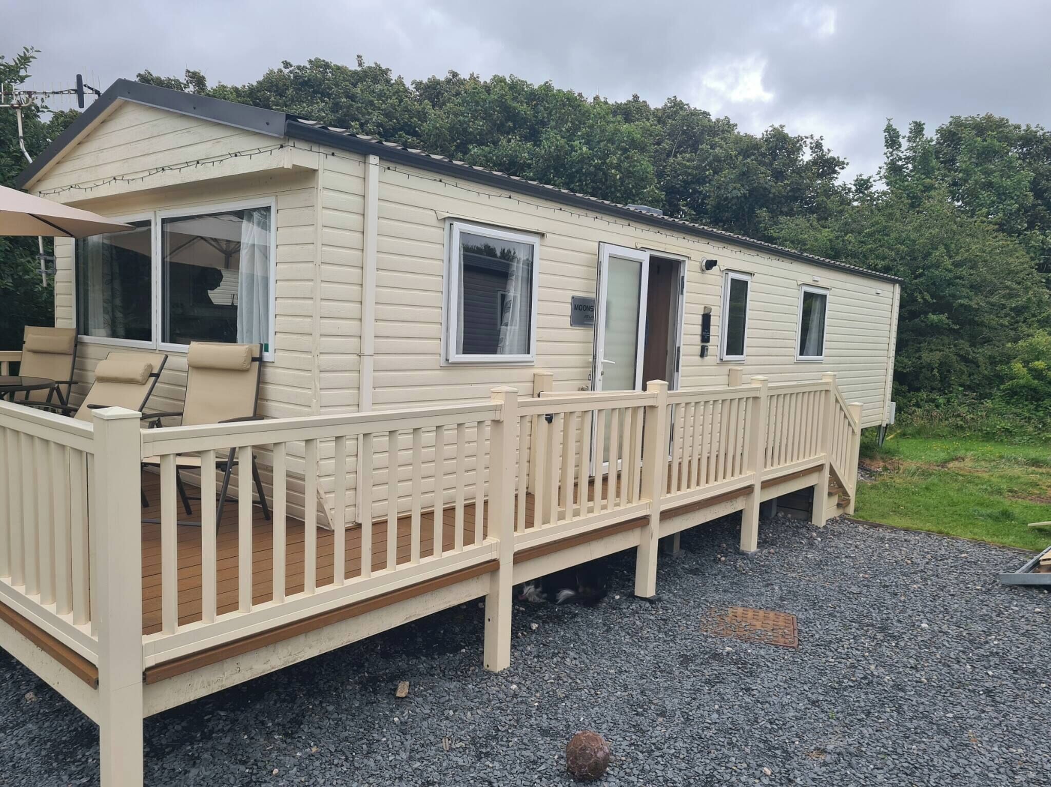 Une maison mobile dotée d’une terrasse et d’un espace extérieur aménagé et couvert.