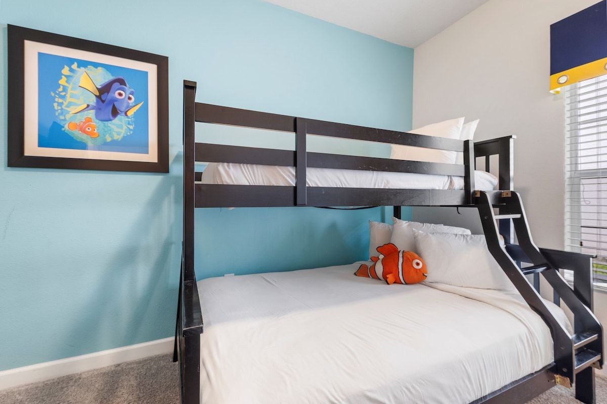 Una cama litera con un cuadro enmarcado de un pez en la pared, una ventana con persianas y piso alfombrado.