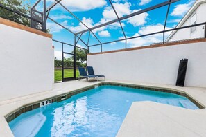 A swimming pool with a clear blue water, surrounded by a white wall and a metal frame structure. - Amazing 5BR•Near Disney•PrivatePool•Water Park (Kissimmee)