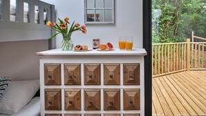 Een ontbijtbuffet met een bloevas, een bord gebakjes en glazen jus d'orange.