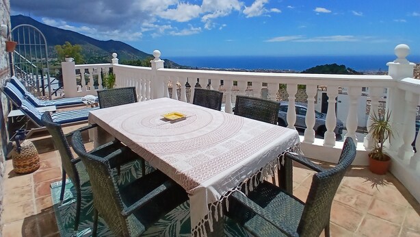 A terrace with a table and chairs, a view of the sea, and a mountainous landscape. - Apartment in the centre of Mijas Pueblo with a large terrace and sea views (Mijas)