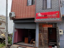A building with a red sign for "Kashirindandan Home Stay" and a smaller sign for "Kamdhenu".