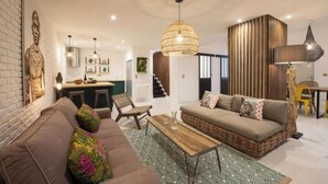 A modern living room with a sofa, a coffee table, and a dining area. - A PERFECT BLEND OF CHARACTER, COMFORT &ARCHITECTURAL CHARM-RUE DU TEMPLE- MARAIS (Paris)