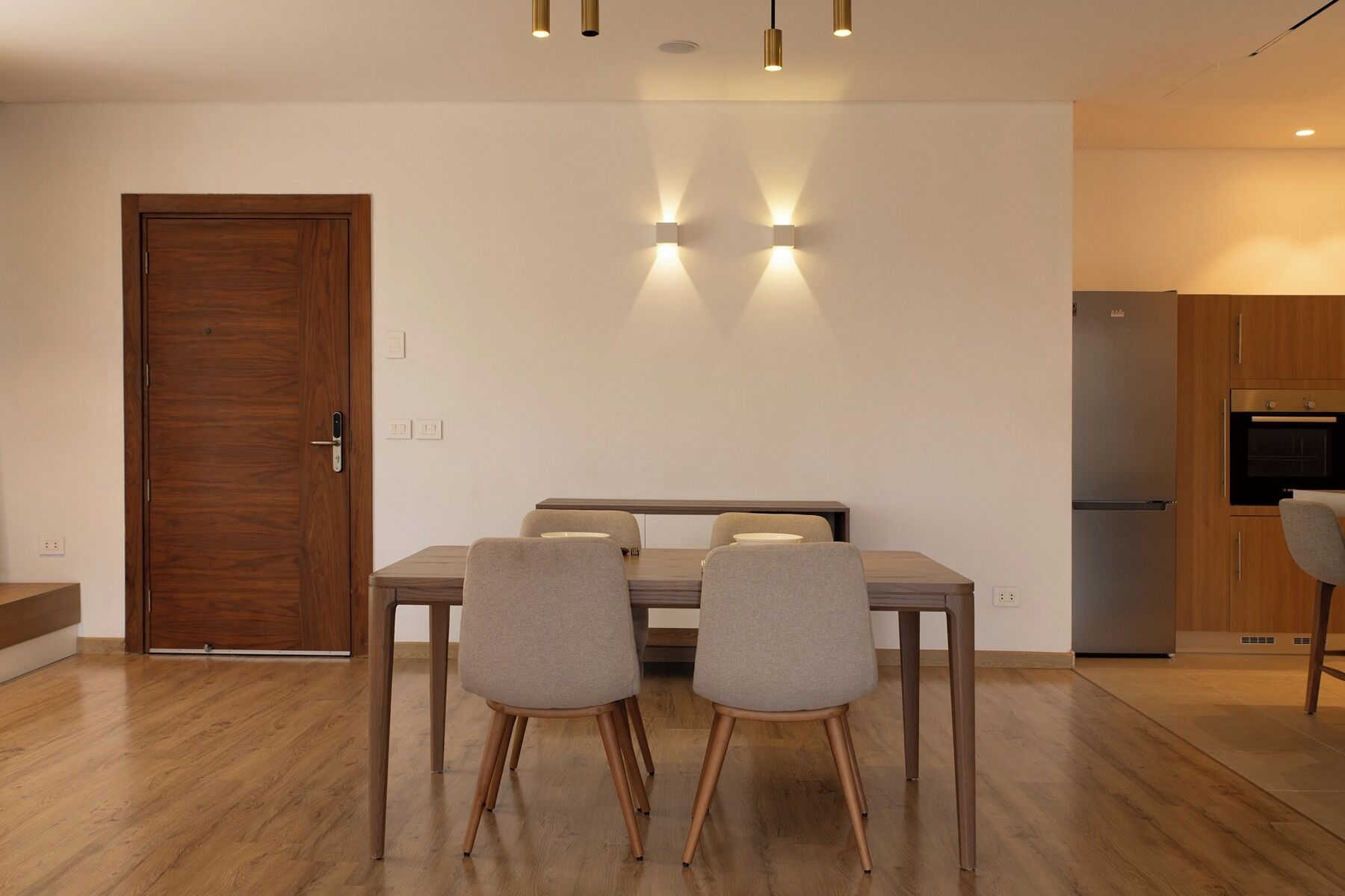A modern kitchen with a built-in oven and a refrigerator.