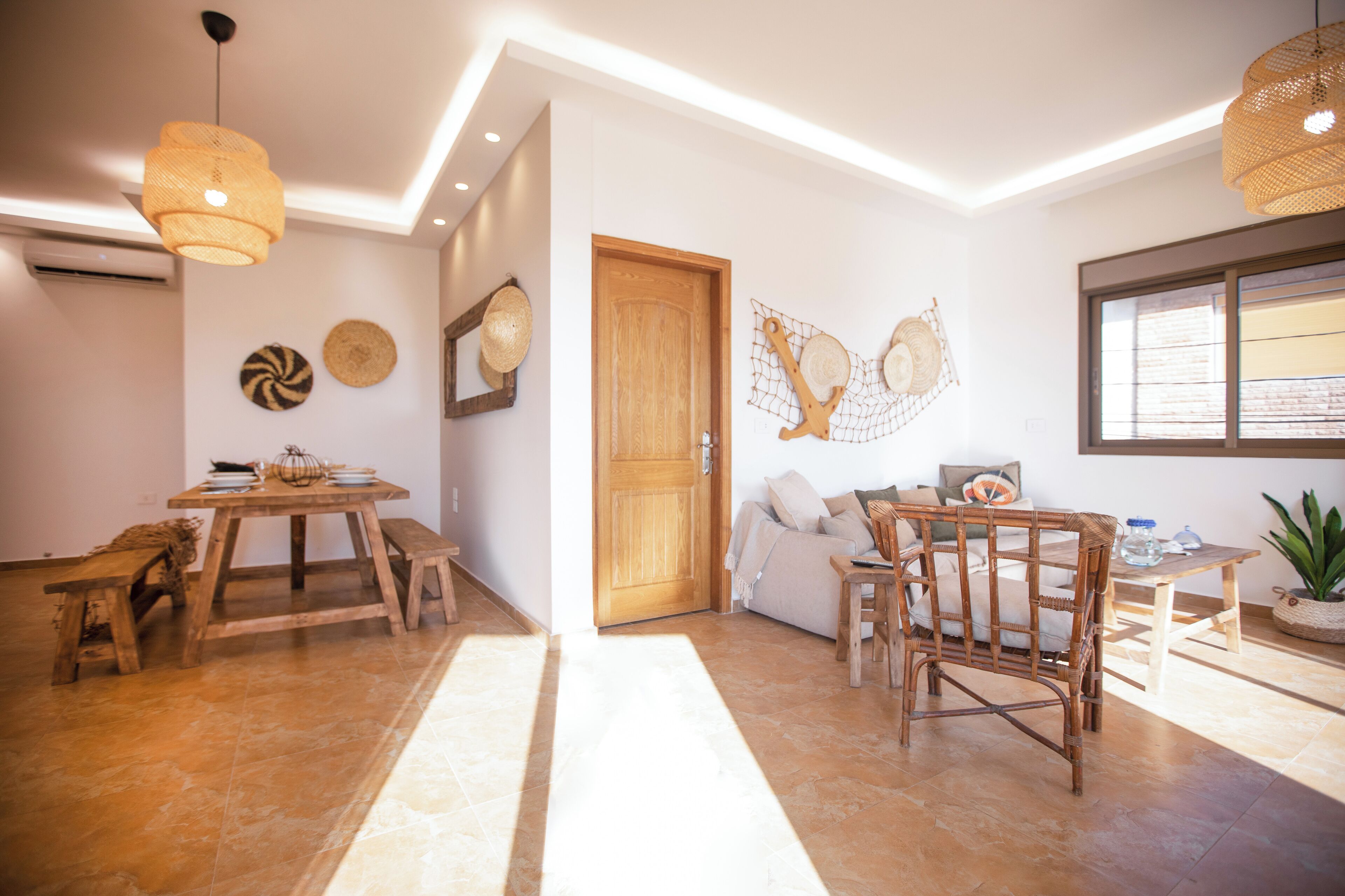 Un soggiorno moderno con un tavolo da pranzo in legno, un divano e una sedia in vimini.