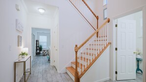 A staircase with wooden steps and white railings leading to a landing.