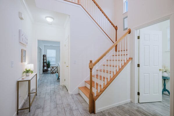 Una escalera con peldaños de madera y barandillas blancas que lleva a una plataforma.