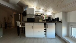 A modern kitchen with white cabinetry, a built-in microwave, and a coffee maker. - Lucciano Suite - Apartment with two bedrooms and bathroom (Quarrata)