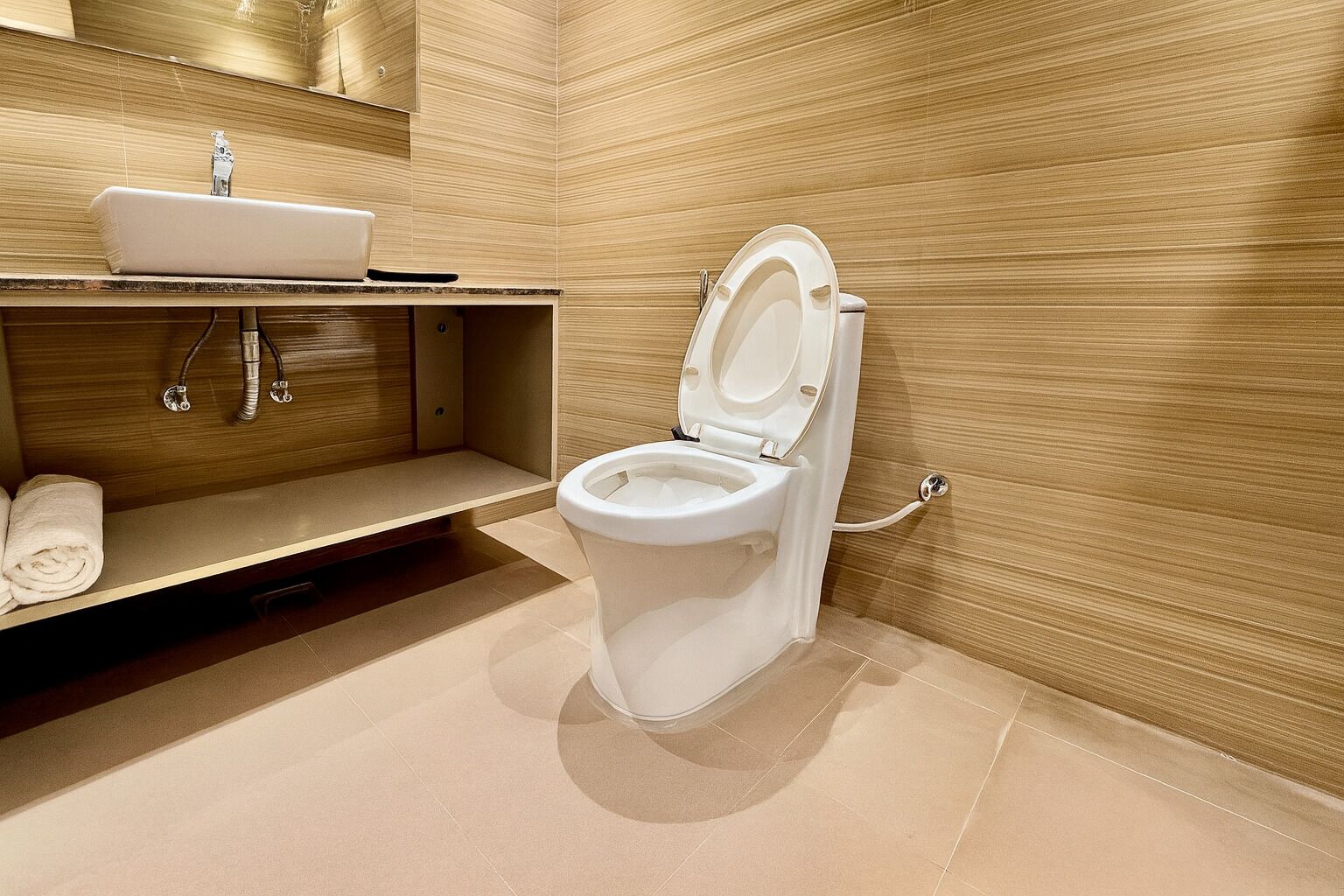Un bagno moderno con il water bianco, un lavandino e un portascopevoli.