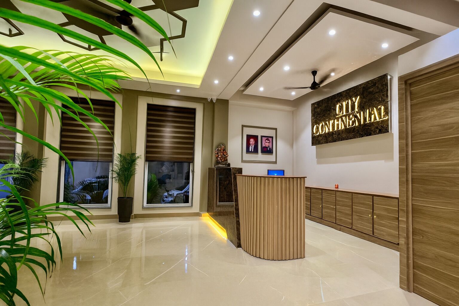 Een hotel receptie met een receptiebalie, een groot bord waarop 