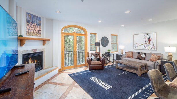A spacious living room with a fireplace, comfortable seating, and large windows. - Bear Creek Lodge 210 1 Bedroom Condo (Telluride)