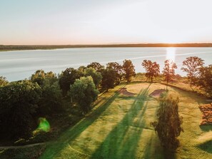 Un campo da golf con un corpo idrico sullo sfondo.