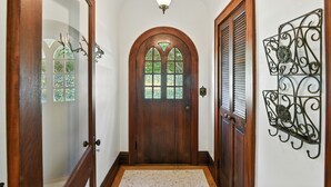 Una puerta de madera con un panel de vidrio y un detalle decorativo de metal en la pared.