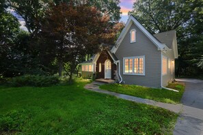A two-story house with a front porch, a small attached garage, and a well-maintained lawn.