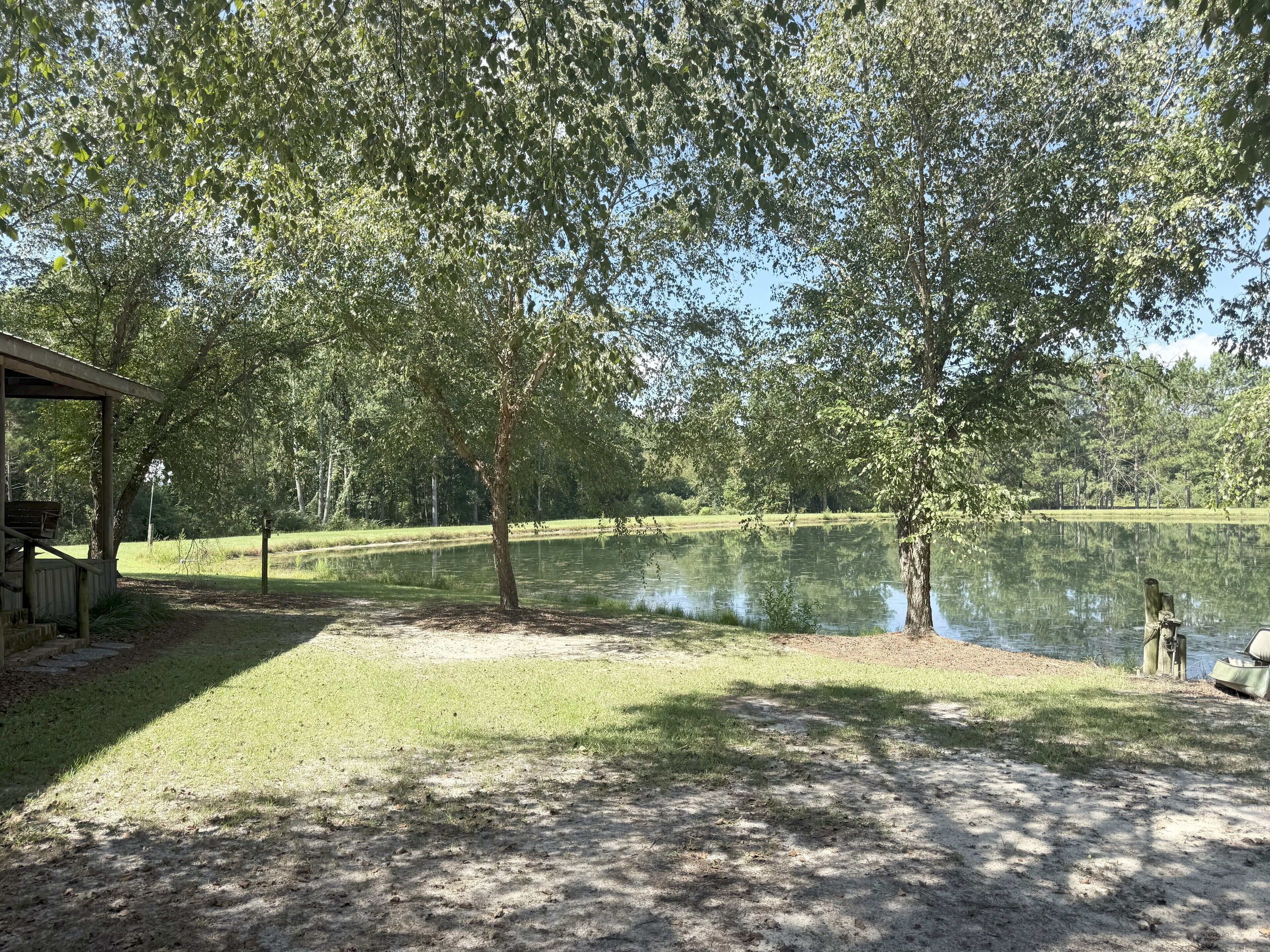 A lakeside campsite with a covered area and a boat dock.