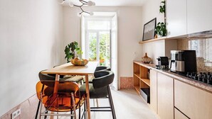 Une cuisine moderne avec une table en bois, des chaises et une machine à café.
