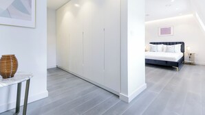 Ein modernes Schlafzimmer mit Bett, Nachttisch und Kleiderschrank.