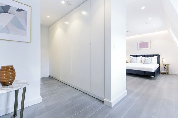 A modern bedroom with a bed, bedside table, and a wardrobe.
