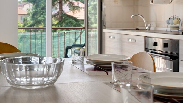 Une cuisine donnant sur un balcon, avec un évier et une cuisinière.