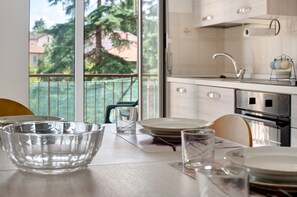 A kitchen with a view of a balcony, a sink, and a stove. - Apartment 'Outlet2000' with Balcony and Wi-Fi (Serravalle Scrivia)