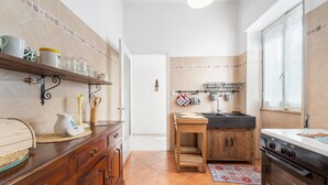 Une cuisine avec des armoires en bois, un plan de travail, un évier et une cuisinière.