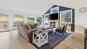 A spacious living room with a large sectional sofa, a coffee table, and a fireplace.