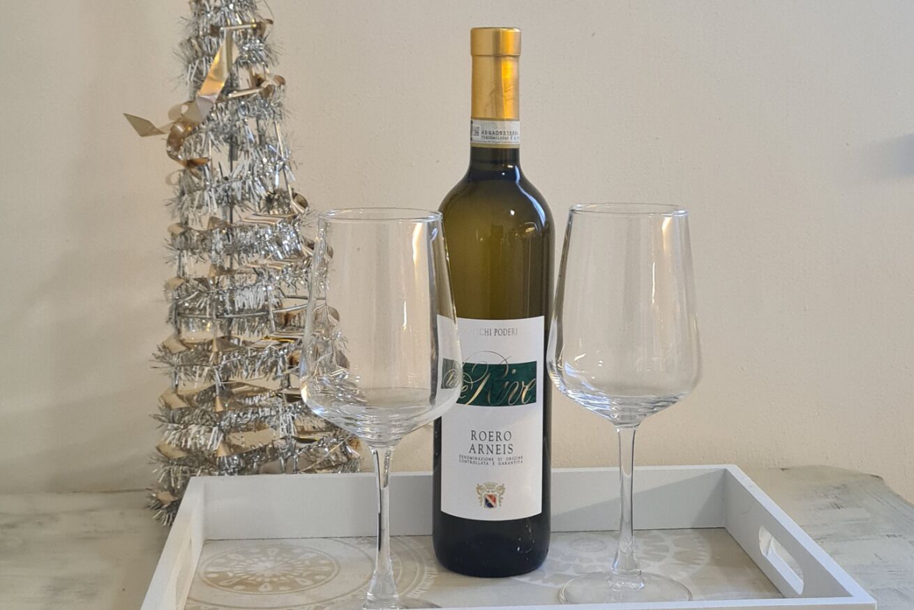 Een fles Roero Arneis wijn op een dienblad met twee lege glazen.