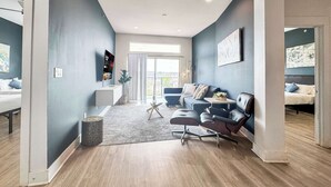 Een moderne woonkamer met een bank, een salontafel en een aan de muur bevestigde televisie.