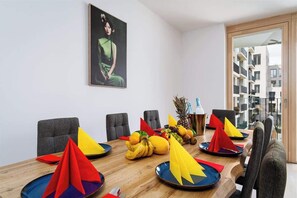 A conference room with a wooden table, colorful paper cones, and a fruit basket. - Bright Royal Elegance (Prague 5)