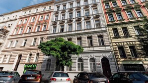 A multi-story building with classical architecture, including arched windows and decorative moldings. - Elephant Signature Penthouse (Prague 2)