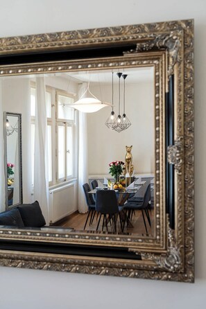 A dining area with a table set for four, a gold cat sculpture, and hanging pendant lights.