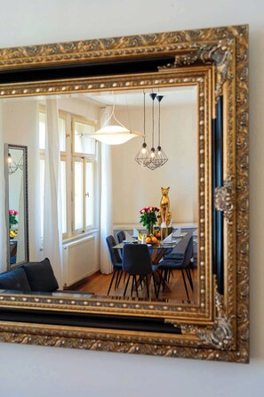 A dining area with a table, chairs, and a decorative golden cat statue.