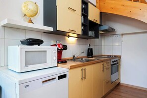 A compact kitchen with a microwave, coffee maker, and a stove. - Royal Elephant Residence (Prague 2)