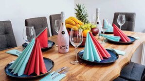 A dining table set with plates, napkins, and a bottle of Múgica Ice Rosé. - Royal Elephant Residence (Prague 2)