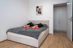 A bedroom with a bed, a wardrobe, and a framed picture on the wall.