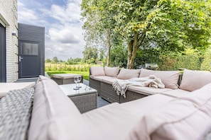 Un espace extérieur aménagé avec un canapé, une table et une chaise.