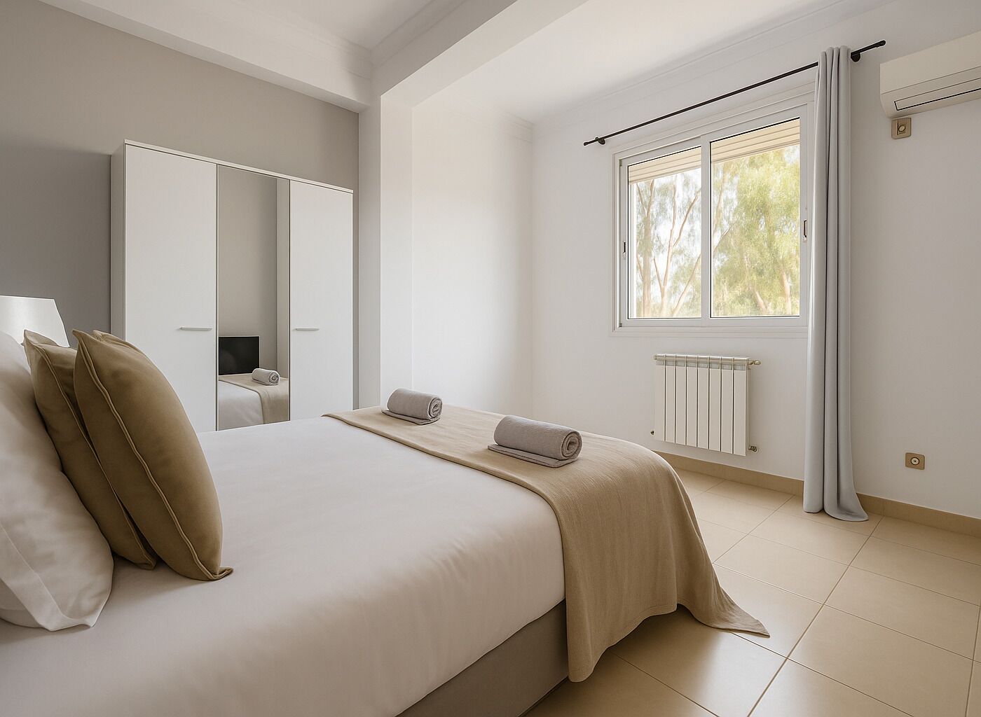 A minimalist bedroom with a large bed, a mirror, a radiator, and a window with curtains.