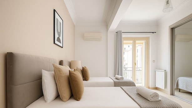 Une chambre d’hôtel avec deux lits, une grande fenêtre et un balcon.
