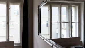Una habitación con cama, ventana y cortina.