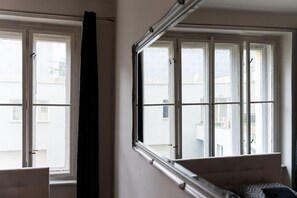 A room with a bed, a window, and a curtain.