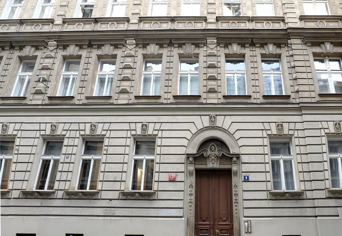 A multi-story building with classical architectural details, including ornate window frames and decorative moldings.